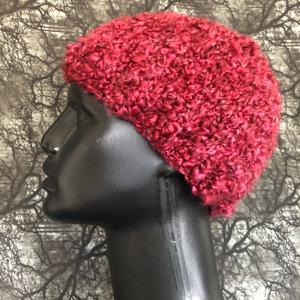 Side view of fuzzy maroon knit hat on a mannequin bust.