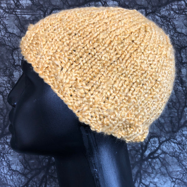 Side view of knit hat on a mannequin head. The hat is made from a bulky and fuzzy yarn.