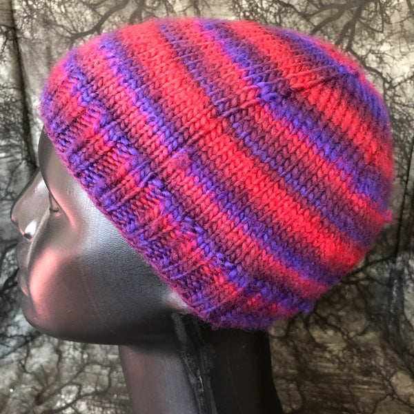 Side view of a knit toque hat on a mannequin bust. The hat has horizontal lines in pink, purple, and blue.
